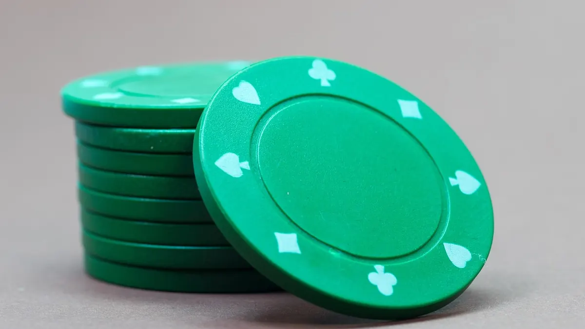 Pokerchips, spillekort og jetoner på grønt spillebord